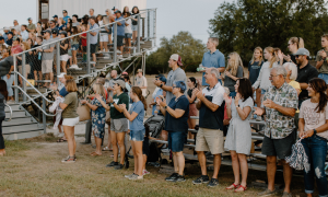 Bracken families standing and clapping in the Bracken football stands.
