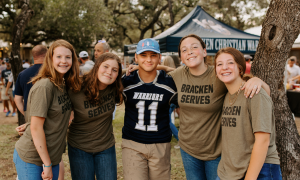 Four female Bracken students wearing Bracken Serves Tshirts and one male student in the middle wearing a Bracken jersey.